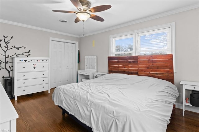 bedroom with visible vents, a closet, ornamental molding, and dark wood-style flooring