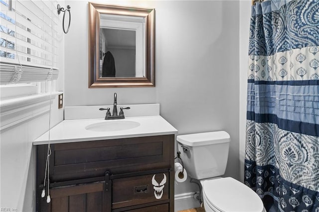 bathroom with toilet, vanity, and a shower with curtain