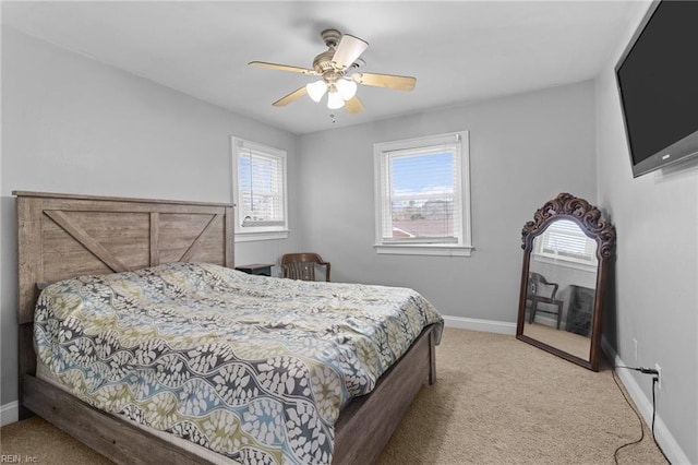 bedroom featuring baseboards, light colored carpet, and a ceiling fan