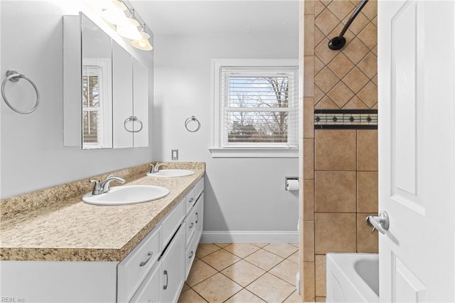 bathroom with a sink, baseboards, double vanity, and tile patterned flooring