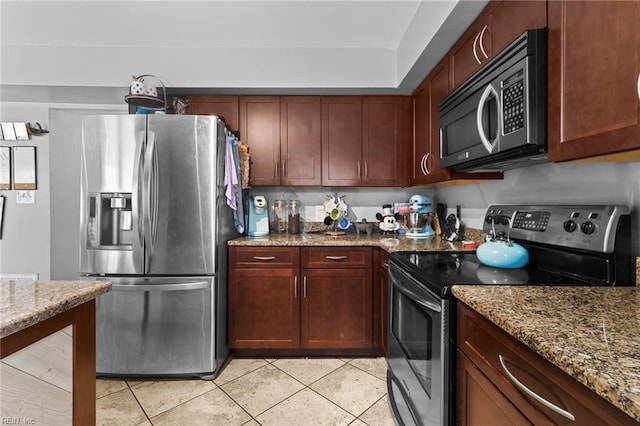 kitchen featuring light stone counters, light tile patterned flooring, and stainless steel appliances