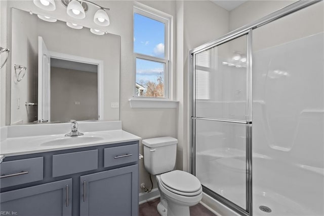 full bathroom featuring vanity, a shower stall, and toilet