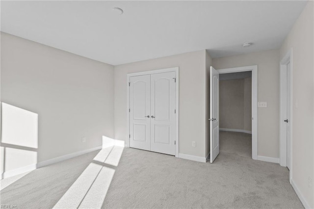 unfurnished bedroom with a closet, baseboards, and carpet floors