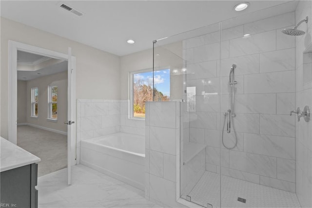 full bathroom with a garden tub, plenty of natural light, visible vents, and tiled shower