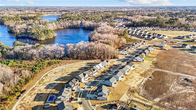 drone / aerial view with a residential view, a forest view, and a water view