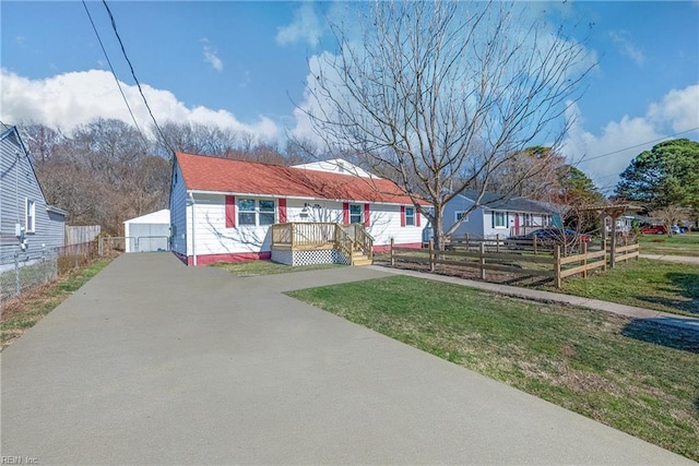 bungalow-style house with a front yard, fence, and driveway