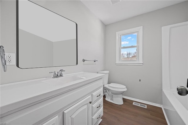 full bathroom featuring visible vents, toilet, wood finished floors, baseboards, and vanity