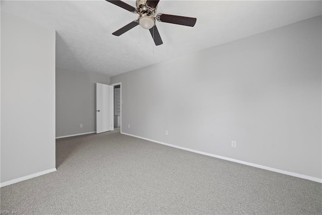 empty room with a ceiling fan, carpet, and baseboards