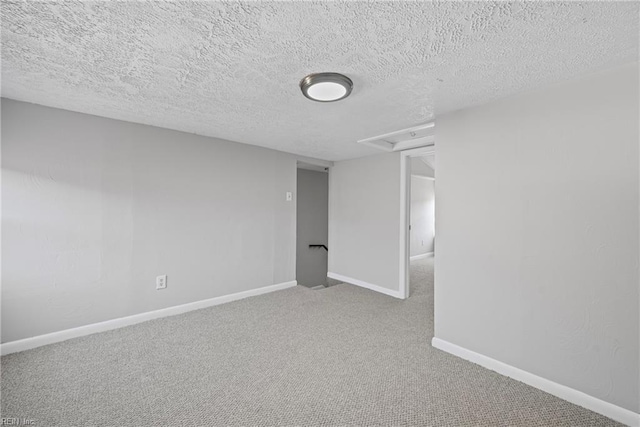 empty room featuring baseboards, carpet floors, and a textured ceiling