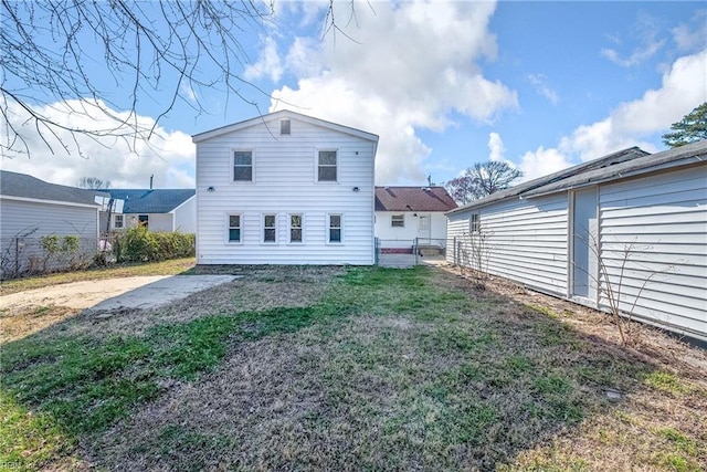 back of house with a lawn and fence