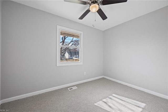 carpeted spare room featuring a ceiling fan, baseboards, and visible vents