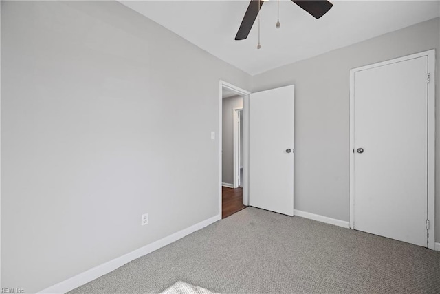 unfurnished bedroom with carpet flooring, a ceiling fan, and baseboards