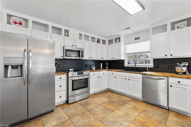 kitchen featuring a sink, appliances with stainless steel finishes, and white cabinets