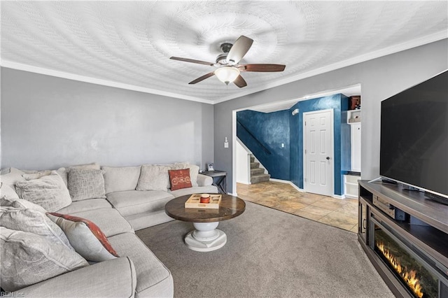 living room featuring carpet, stairway, ornamental molding, a textured ceiling, and a ceiling fan