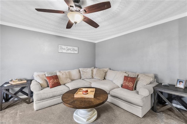 carpeted living room with ceiling fan and ornamental molding