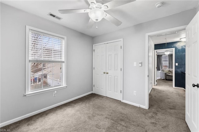 unfurnished bedroom with attic access, baseboards, visible vents, and carpet floors