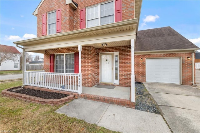 traditional home with brick siding, a porch, driveway, and a garage