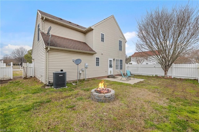 back of house with a lawn, a patio, a fenced backyard, an outdoor fire pit, and central AC unit