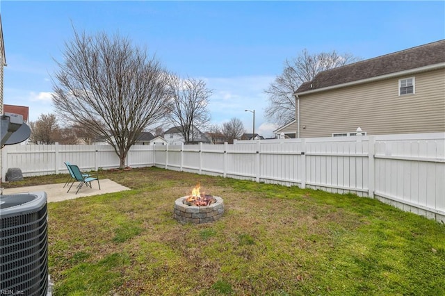 view of yard with a patio area, central air condition unit, a fire pit, and a fenced backyard