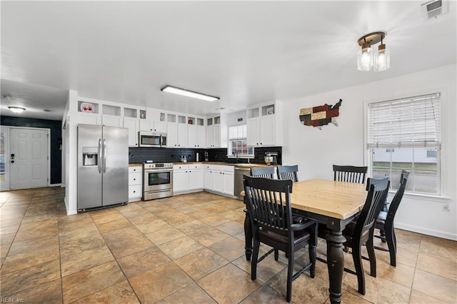 kitchen with tasteful backsplash, visible vents, baseboards, appliances with stainless steel finishes, and white cabinetry