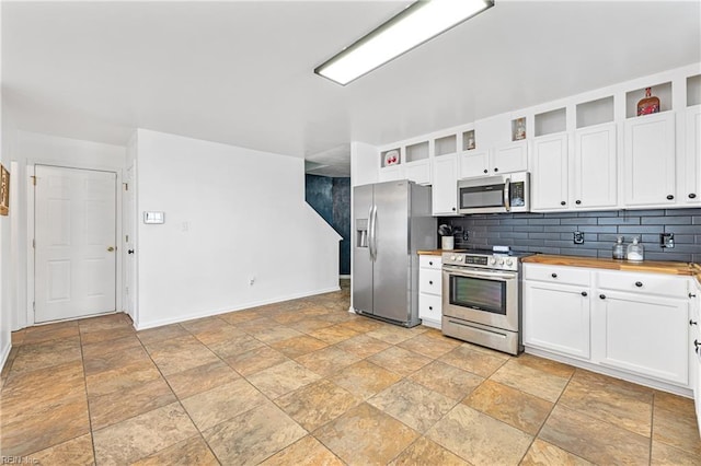 kitchen featuring backsplash, appliances with stainless steel finishes, white cabinets, wood counters, and open shelves