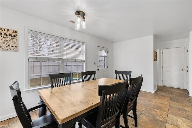 dining area featuring visible vents, stone finish flooring, and baseboards