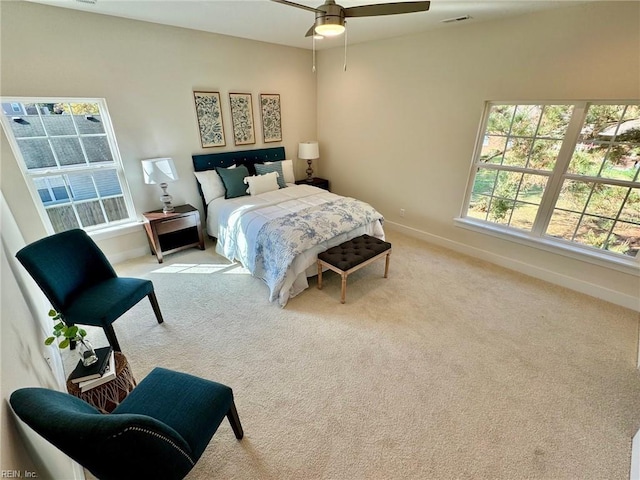 carpeted bedroom featuring visible vents, a ceiling fan, and baseboards