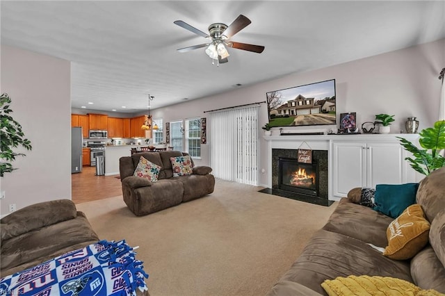 living area with recessed lighting, light carpet, ceiling fan, and a fireplace