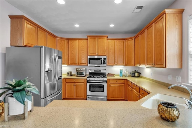 kitchen featuring visible vents, light countertops, recessed lighting, stainless steel appliances, and a sink