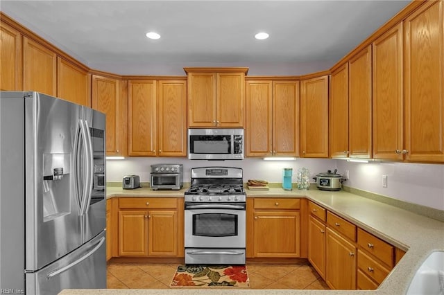 kitchen featuring a toaster, light tile patterned flooring, recessed lighting, stainless steel appliances, and light countertops