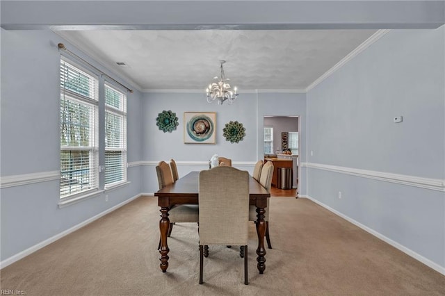 carpeted dining room featuring visible vents, baseboards, a notable chandelier, and crown molding