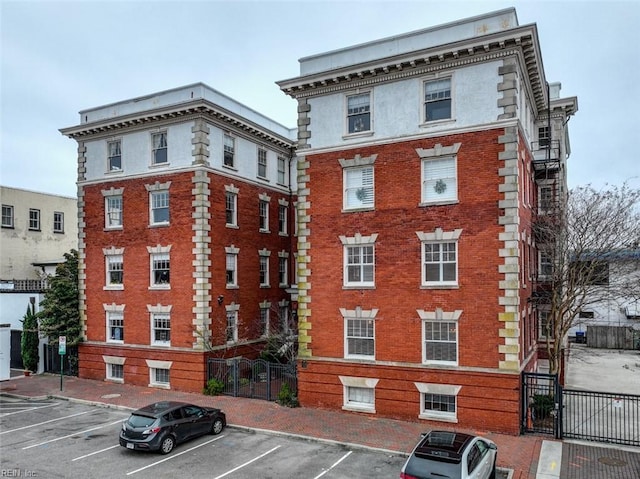 view of property with uncovered parking and fence