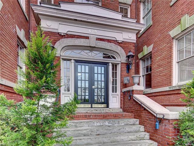 property entrance featuring french doors and brick siding