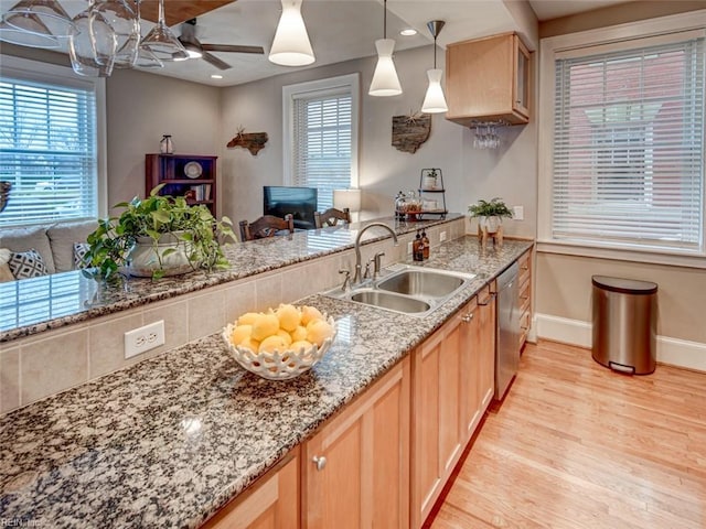 kitchen featuring a sink, ceiling fan, light stone counters, light wood-style flooring, and stainless steel dishwasher