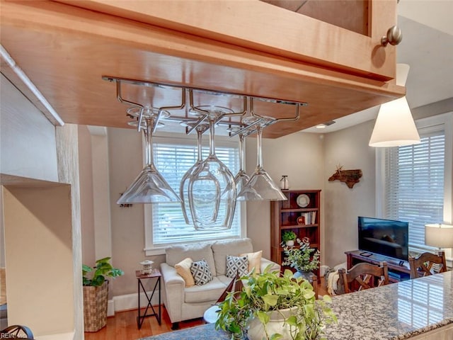 living area with wood finished floors, baseboards, and a chandelier