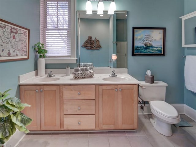 bathroom featuring tile patterned flooring, toilet, and a sink