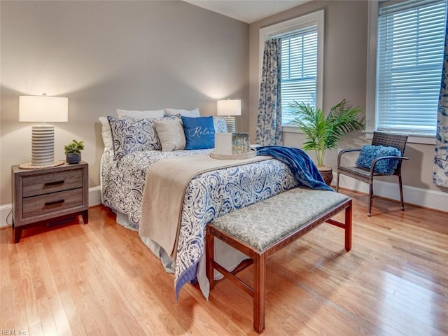 bedroom featuring light wood finished floors and baseboards