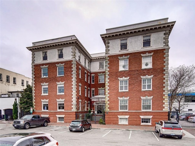 view of building exterior featuring uncovered parking and fence