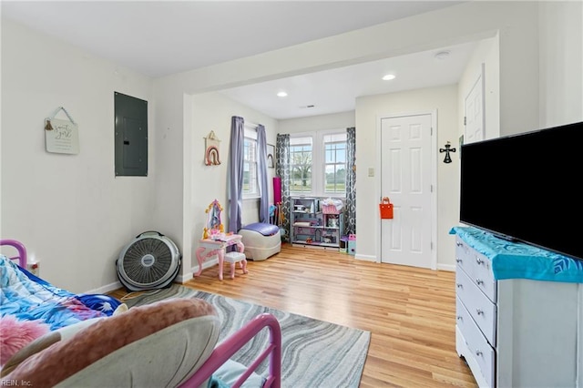 living room featuring electric panel, baseboards, light wood-style flooring, and recessed lighting