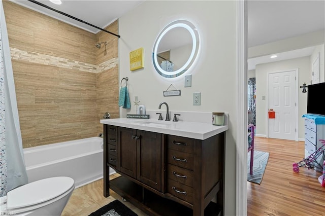bathroom featuring vanity, toilet, wood finished floors, and shower / bath combo