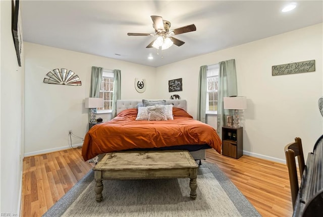 bedroom featuring baseboards, multiple windows, and wood finished floors