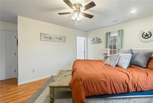 bedroom featuring visible vents, wood finished floors, baseboards, and ceiling fan