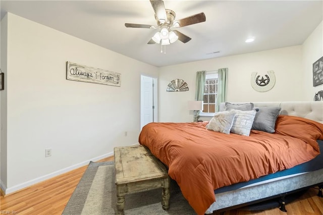 bedroom featuring baseboards, light wood-type flooring, and ceiling fan