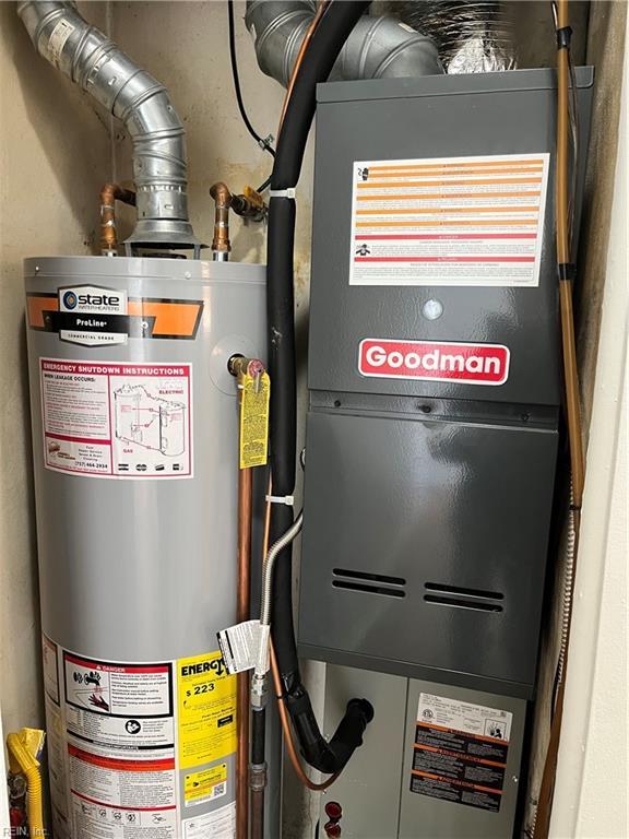 utility room featuring heating unit and water heater