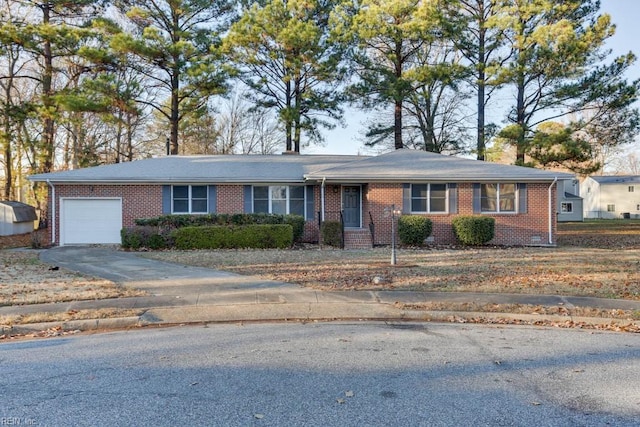 ranch-style home with a garage, brick siding, and driveway