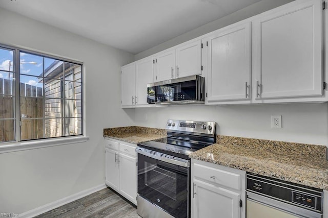 kitchen featuring light stone counters, white cabinetry, and stainless steel appliances