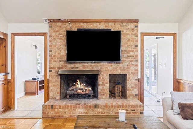 living area featuring light tile patterned floors and a brick fireplace