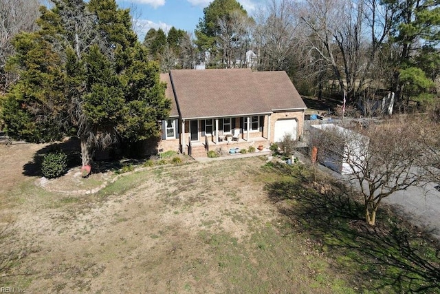 cape cod house with driveway, covered porch, and an attached garage