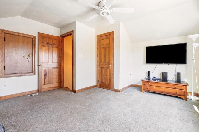 interior space with visible vents, light colored carpet, baseboards, and lofted ceiling