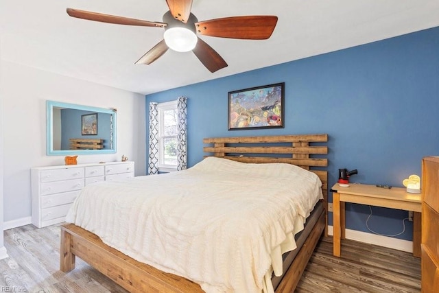 bedroom with ceiling fan, baseboards, and wood finished floors